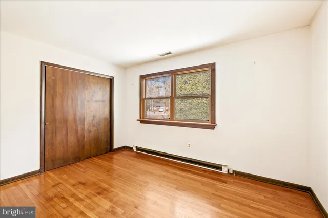 a view of an empty room with wooden floor