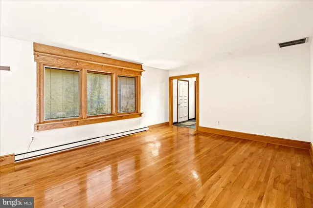 a view of an empty room with a fireplace and a window