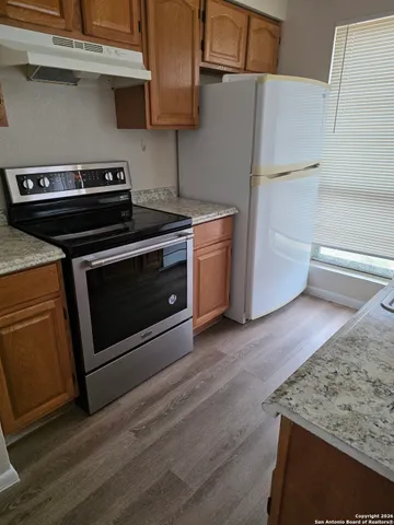 a view of a kitchen with furniture and wooden floor