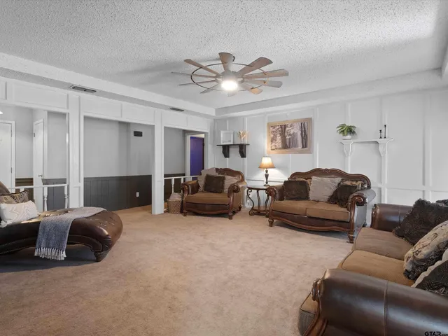 a living room with furniture ceiling fan and a rug