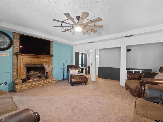 a living room with furniture a flat screen tv and a fireplace