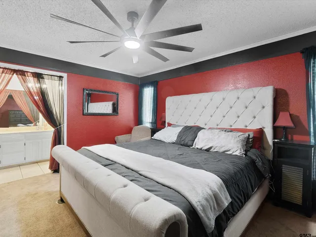 a bedroom with a large bed and a chandelier