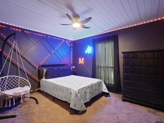 a bedroom with a bed a chandelier and a dresser