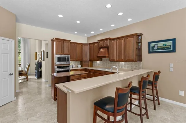 a kitchen with cabinets a sink and chairs