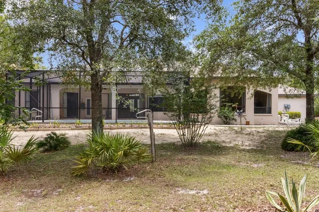 an aerial view of a house with yard and trees