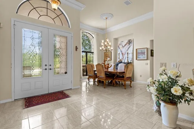 a dining room with furniture a chandelier and window