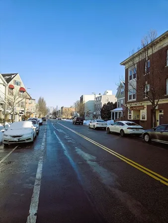 a view of city street with a parked cars side of road