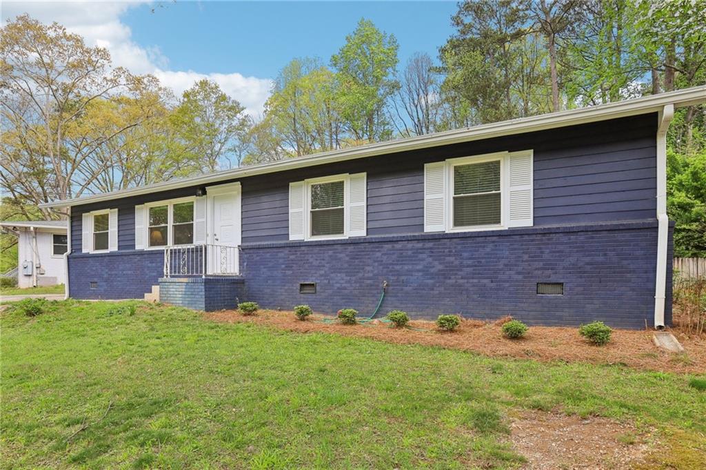2407 Ridgeway Drive Doraville, GA 30360 - Photo 1 of 1 a brick house with a yard plants and large tree