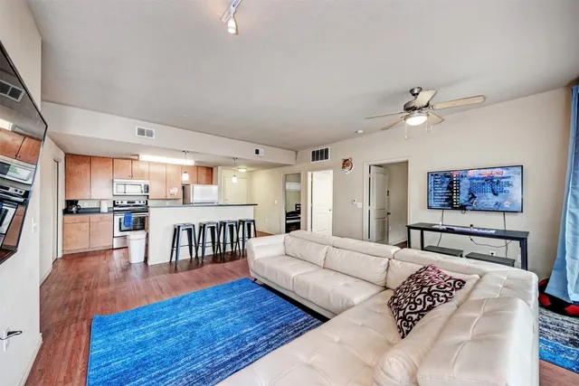 a living room with furniture and a view of kitchen