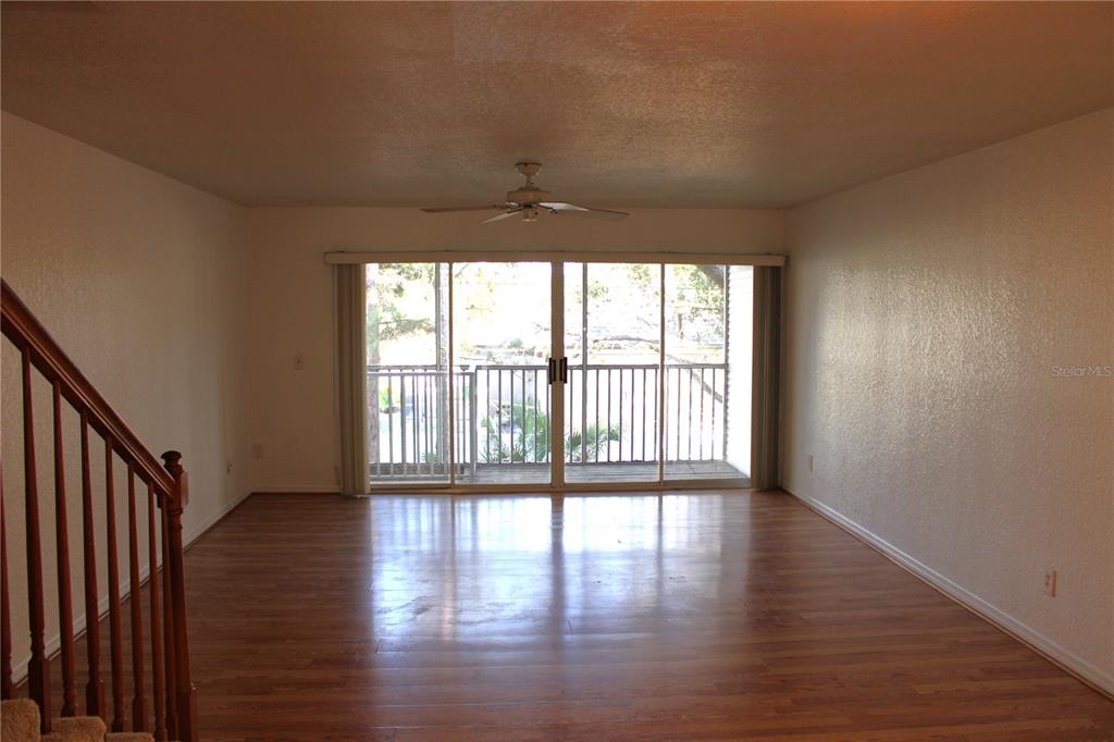 9720 Indian Key Trail, Unit 117 Seminole, FL 33776 - Photo 13 of 92 a view of an empty room with wooden floor and a window