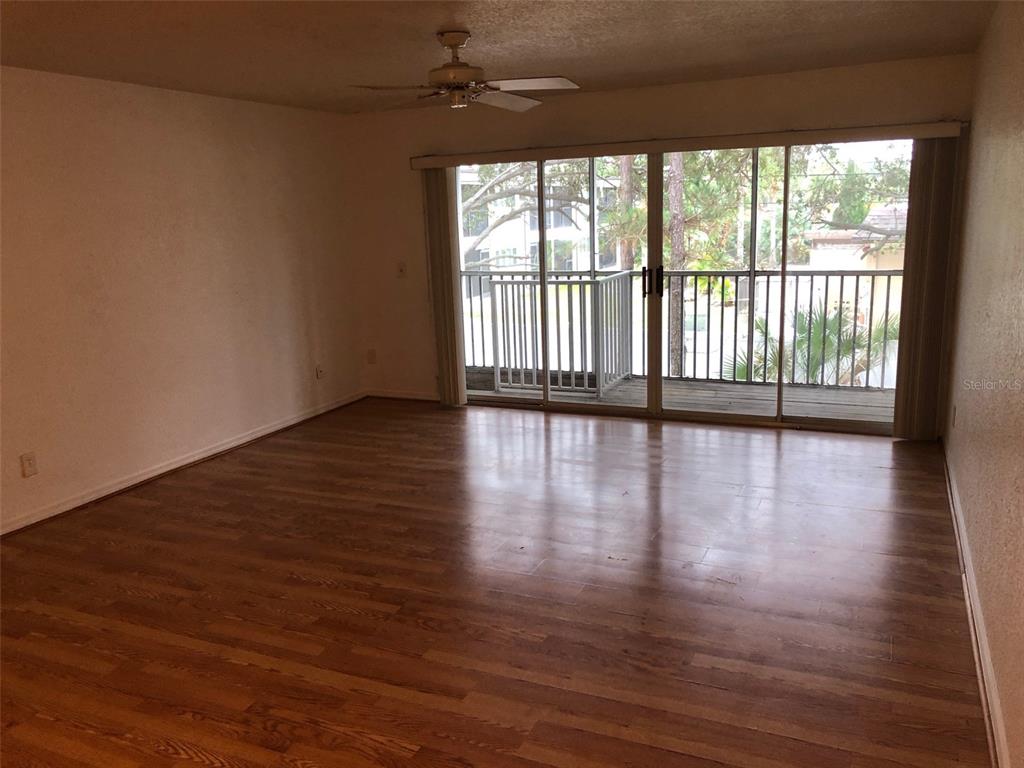 9720 Indian Key Trail, Unit 117 Seminole, FL 33776 - Photo 2 of 92 a view of an empty room with wooden floor and a window