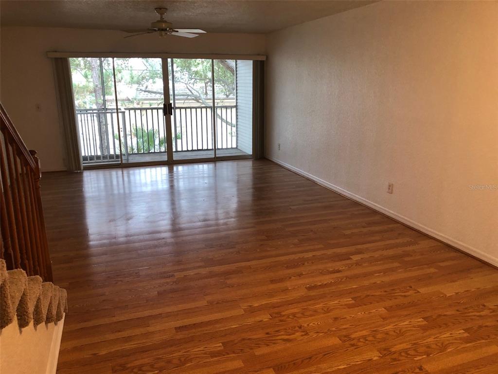 9720 Indian Key Trail, Unit 117 Seminole, FL 33776 - Photo 10 of 92 a view of empty room with wooden floor and fan