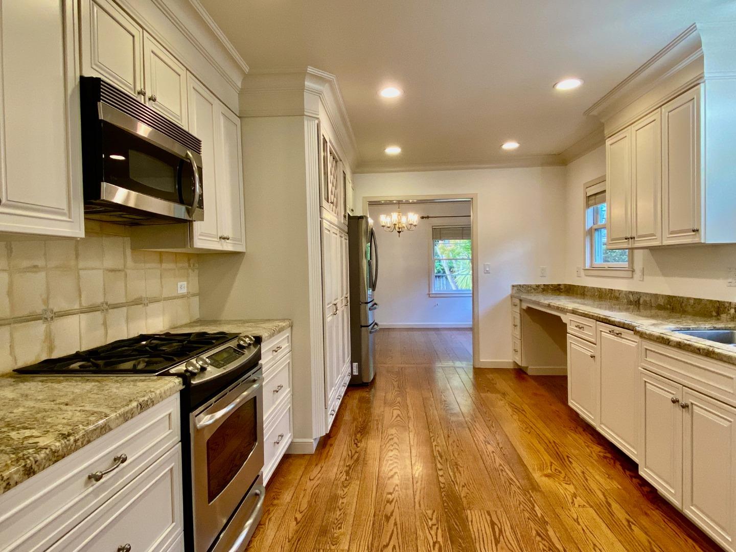 569 Alhambra Road San Mateo, CA 94402 - Photo 11 of 30 a kitchen with stainless steel appliances granite countertop wooden cabinets a stove top oven a sink and dishwasher