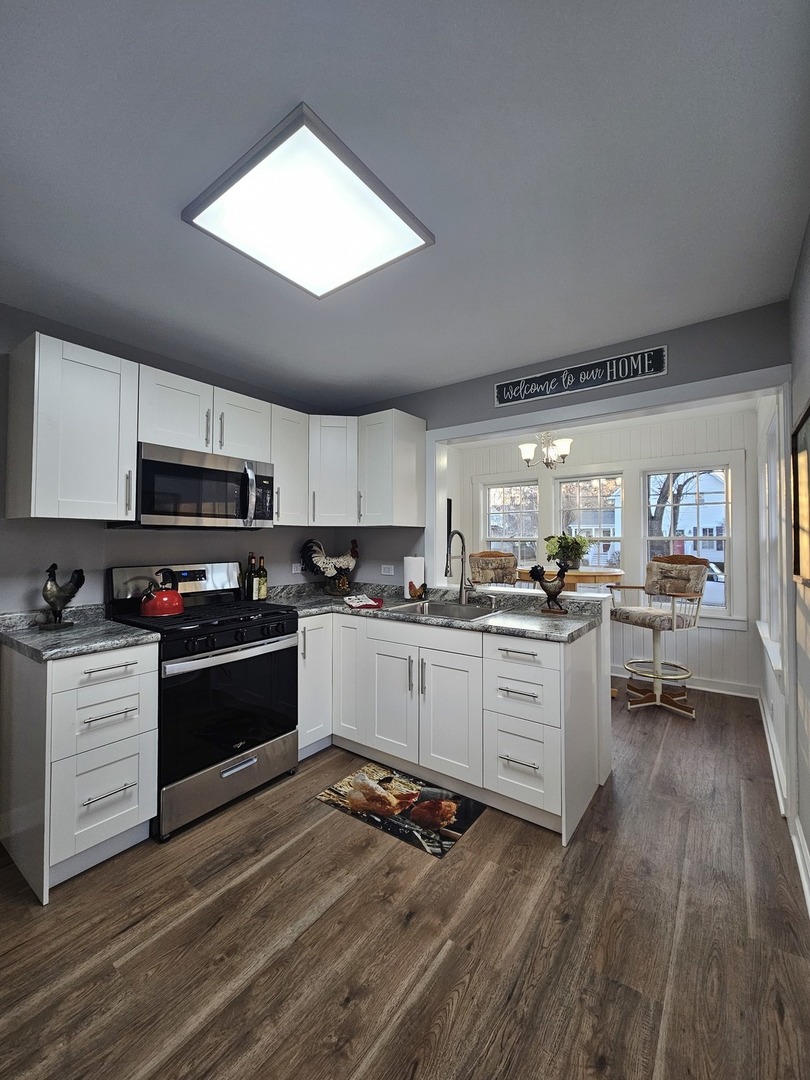 220 South Walnut Street Sycamore, IL 60178 - Photo 4 of 13 a kitchen with granite countertop a stove cabinets and wooden floor
