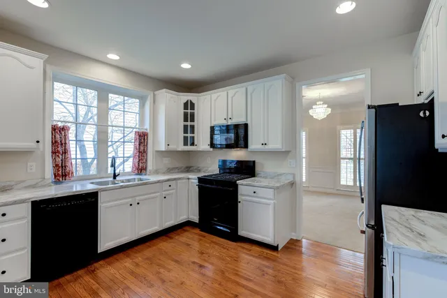 a kitchen with granite countertop a refrigerator stove top oven and sink