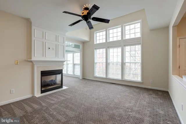 an empty room with windows and fireplace