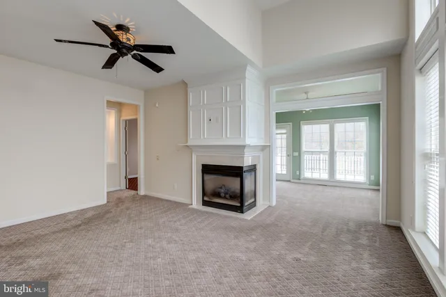 an empty room with a kitchen view and a window