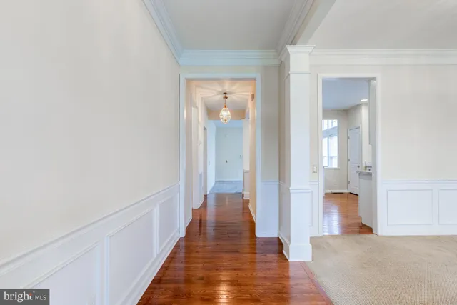 a view of a hallway with wooden floor and staircase