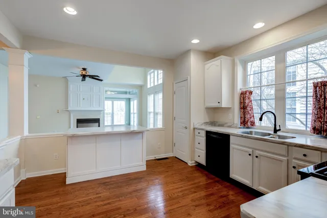 a kitchen with stainless steel appliances granite countertop a sink cabinets and wooden floor
