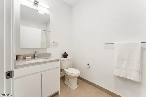 a bathroom with a granite countertop sink a toilet and a mirror