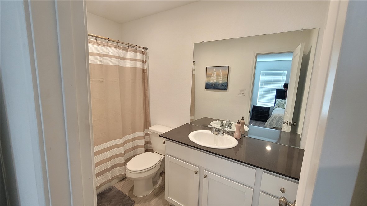 3206 Lancer Street Robstown, TX 78380 - Photo 15 of 23 a bathroom with a granite countertop sink toilet and mirror