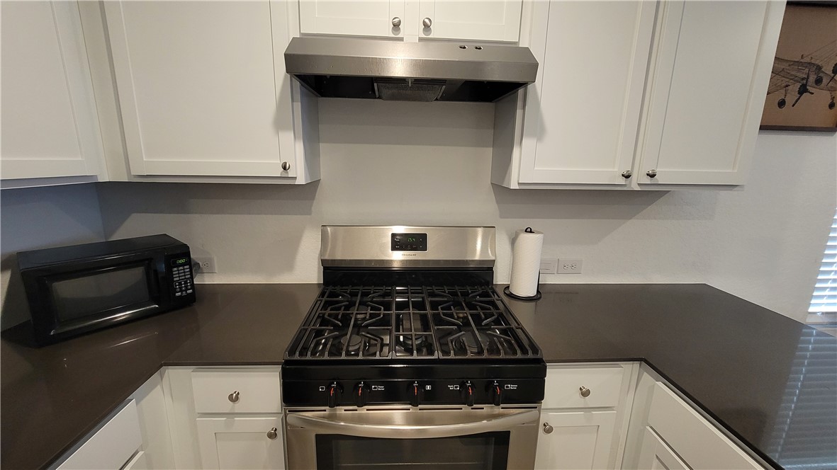 3206 Lancer Street Robstown, TX 78380 - Photo 10 of 23 a kitchen with granite countertop a stove and a white cabinets