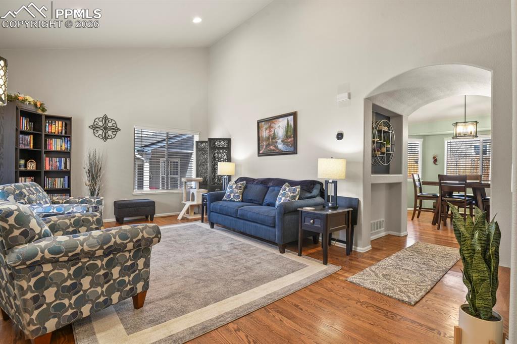 3265 Flying Horse Road Colorado Springs, CO 80922 - Photo 8 of 43 The front living room with beautiful hardwood flooring and an arched entry way to the rest of the house