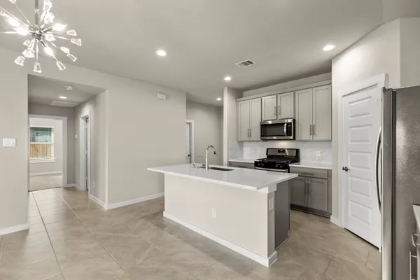 a kitchen with kitchen island a sink stainless steel appliances and cabinets
