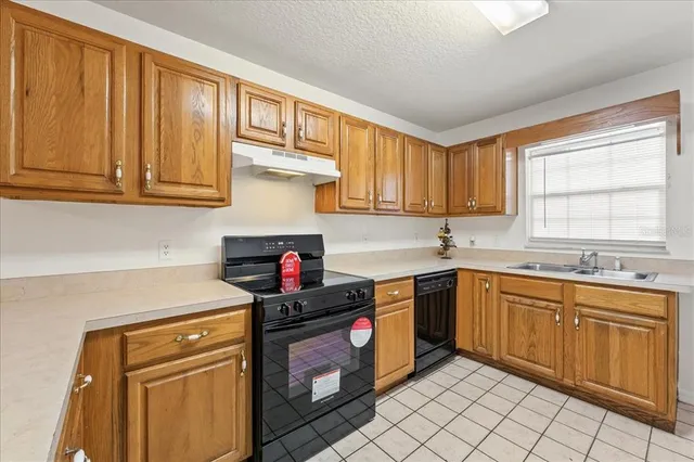 a kitchen with granite countertop cabinets stainless steel appliances a sink and a window
