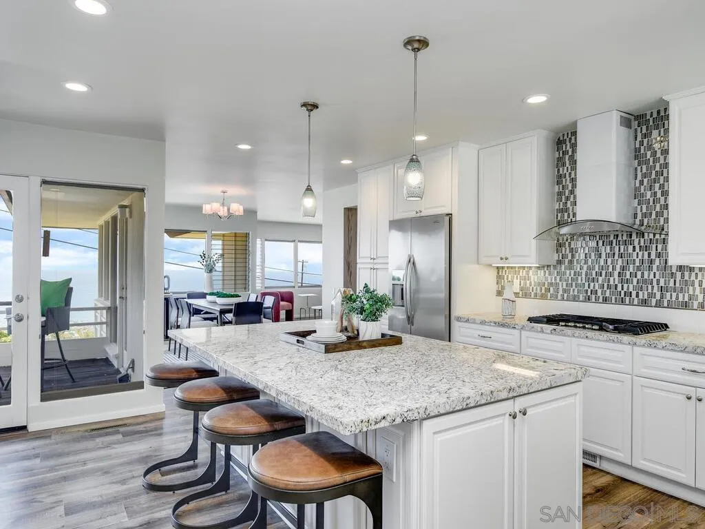1010 La Jolla Rancho Road La Jolla, CA 92037 - Photo 1 of 35 a kitchen with granite countertop a stove a sink a dining table and chairs