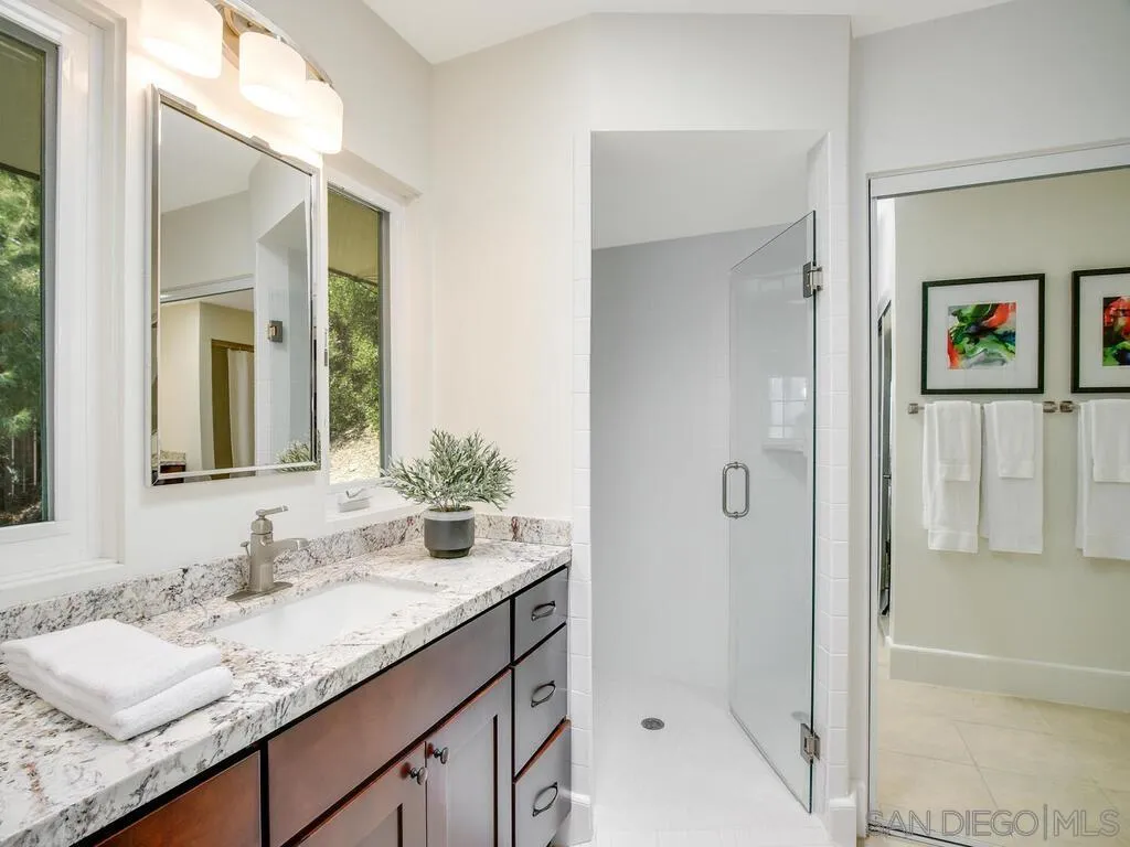 1010 La Jolla Rancho Road La Jolla, CA 92037 - Photo 21 of 35 a bathroom with a granite countertop sink and a mirror