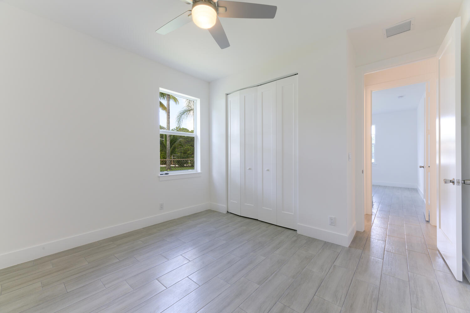 18050 Limestone Creek Road Jupiter, FL 33458 - Photo 14 of 26 an empty room with wooden floor and windows
