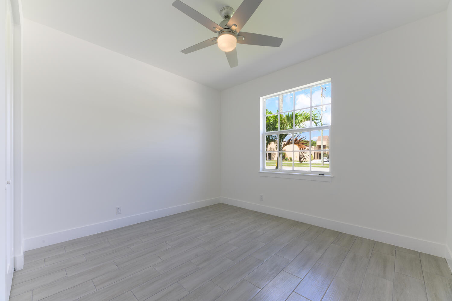 18050 Limestone Creek Road Jupiter, FL 33458 - Photo 18 of 26 an empty room with wooden floor ceiling fan and windows