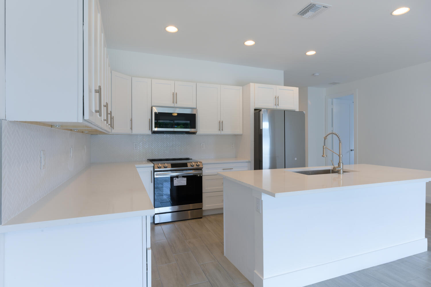 18050 Limestone Creek Road Jupiter, FL 33458 - Photo 23 of 26 a kitchen with kitchen island a sink stainless steel appliances and counter space
