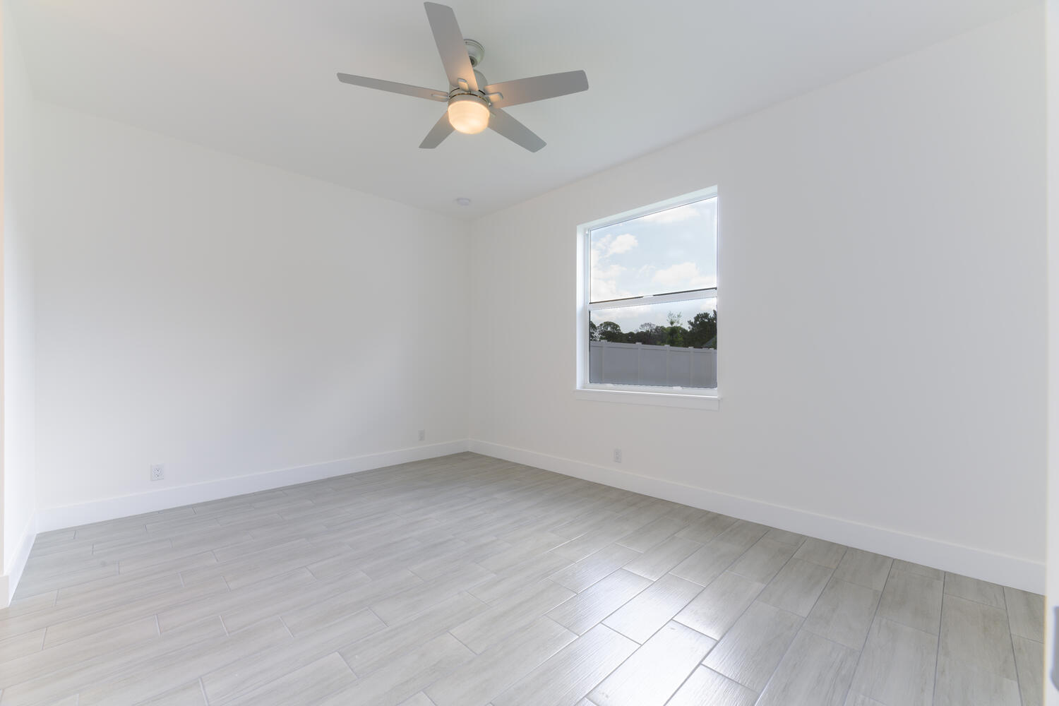 18050 Limestone Creek Road Jupiter, FL 33458 - Photo 24 of 26 an empty room with a window and ceiling fan