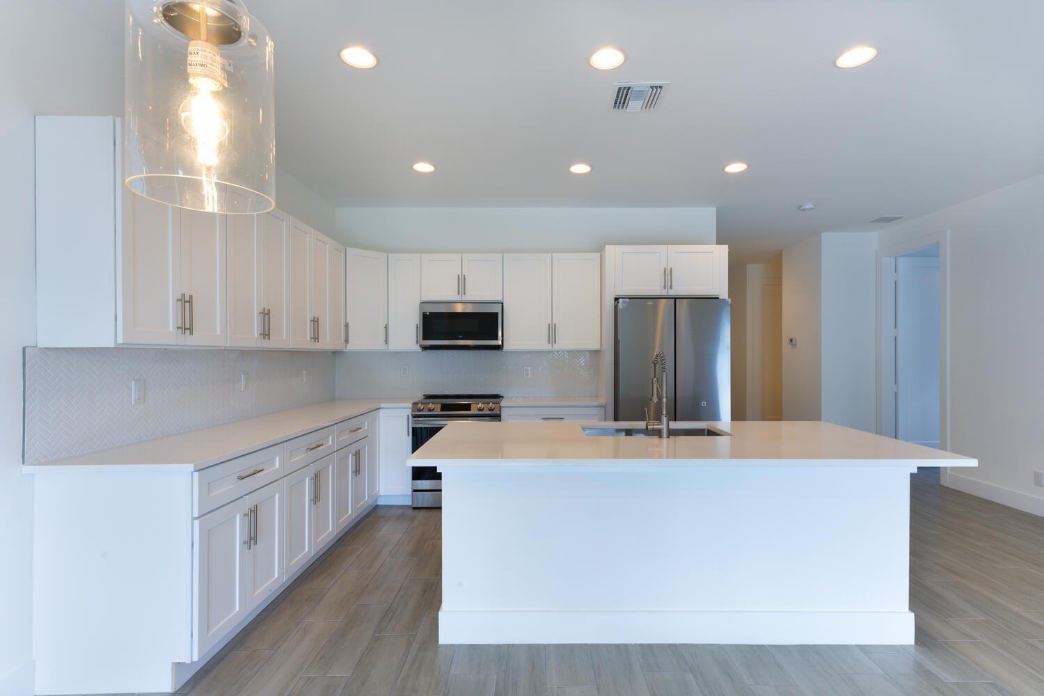 18050 Limestone Creek Road Jupiter, FL 33458 - Photo 7 of 26 a large kitchen with stainless steel appliances a large counter top and a stove top oven