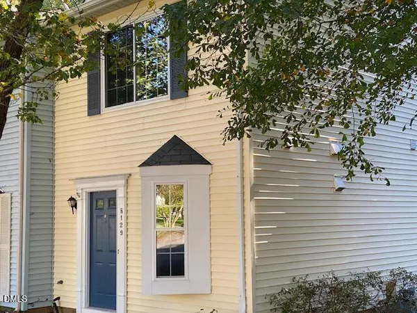 a front view of a house with a tree