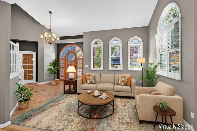 a living room with furniture a chandelier and a window