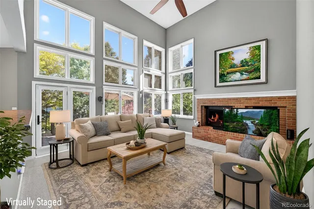 a living room with furniture large window and a fireplace