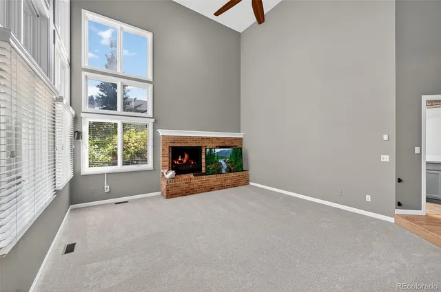 an empty room with windows and fireplace