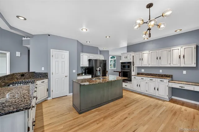 a large kitchen with stainless steel appliances granite countertop a stove oven and a refrigerator