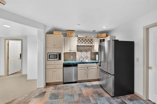 a kitchen with stainless steel appliances a refrigerator sink and cabinets