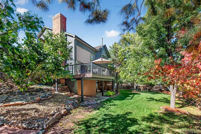 a view of a house with a yard and a tree