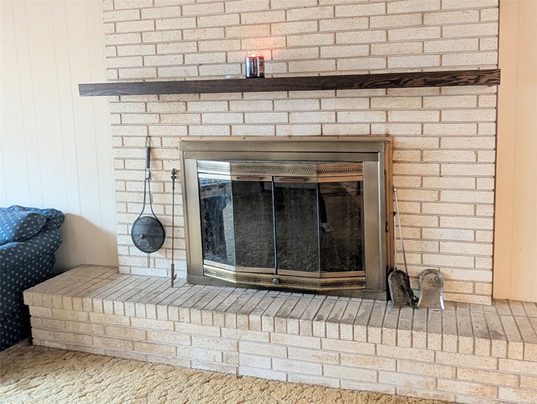 4779 Mixville Road Sealy, TX 77474 - Photo 8 of 47 Cozy brick fireplace with a metal screen and a wooden mantel. The surrounding area includes a hearth for seating or decorations. It's a focal point for the living space and ideal for warmth and ambiance.