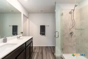 a bathroom with a sink a toilet a mirror and shower