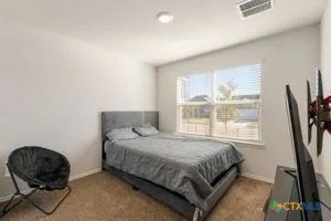 a bedroom with a bed chair and a window