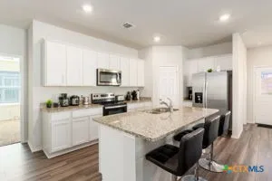 a kitchen with granite countertop a sink stove and refrigerator