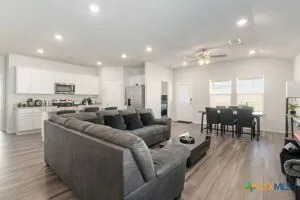 a living room with lots of furniture and kitchen view