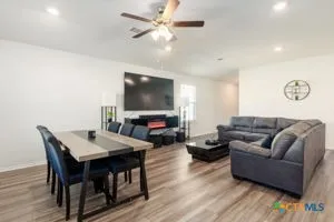 a living room with furniture a flat screen tv and a table