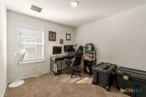 a view of a workspace with furniture and a window